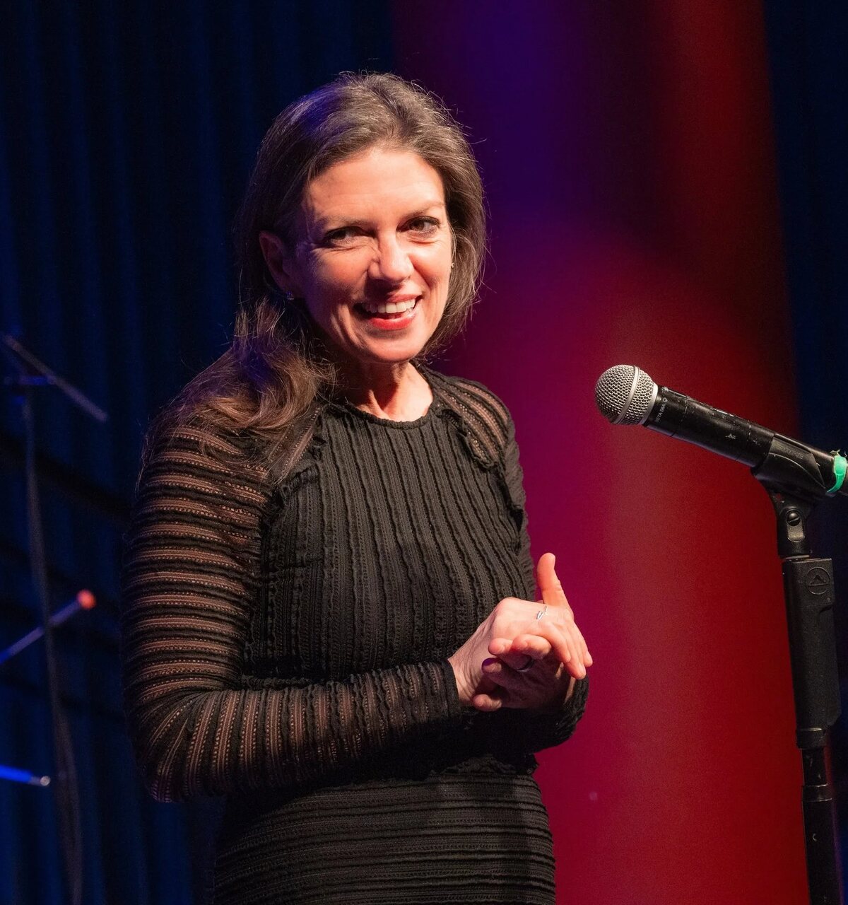 Kimberly Senior smiling at a microphone on stage at the Primary Stages Variety Show benefit, 2026