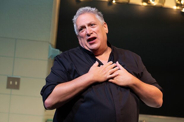 Harvey Fierstein as Bella Abzug with his hands pressed to his chest in Bella Bella