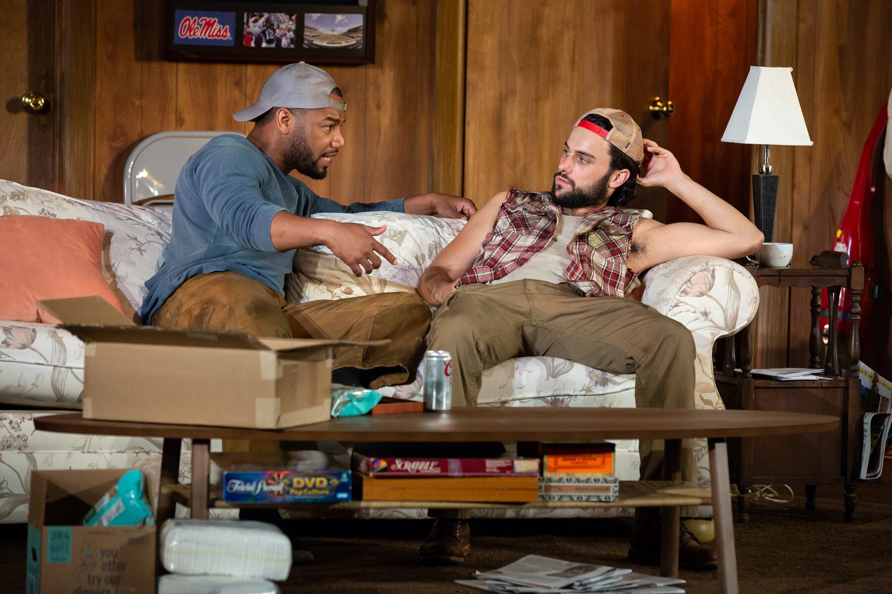 Two actors on the sofa of the living-room set