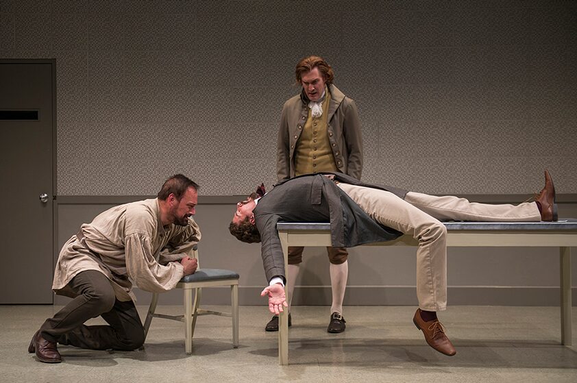 A man lying on an examination table between two others in a tense confrontation in Discord
