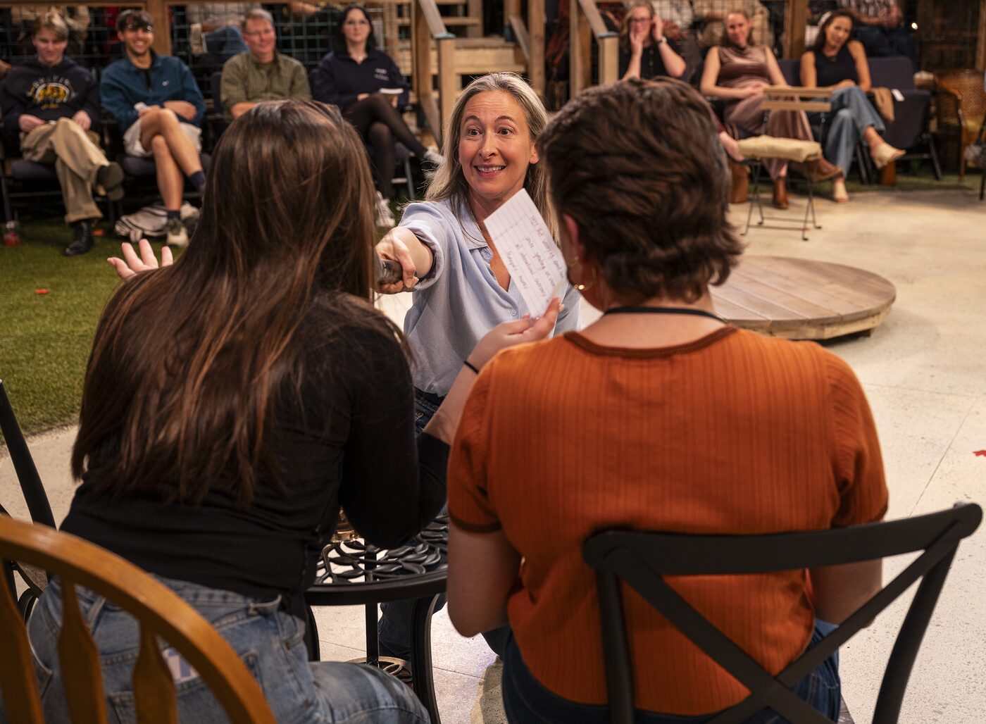 Jessie Fisher hands a slip of paper to an audience member in Every Brilliant Thing