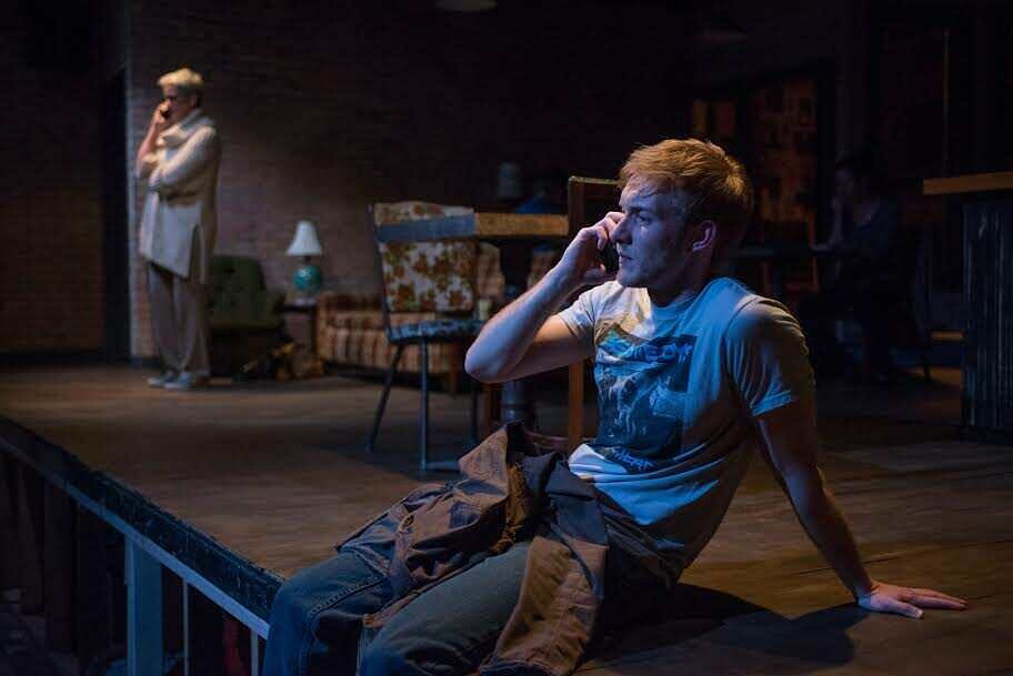 A young man on the phone at the edge of the stage in The Great God Pan