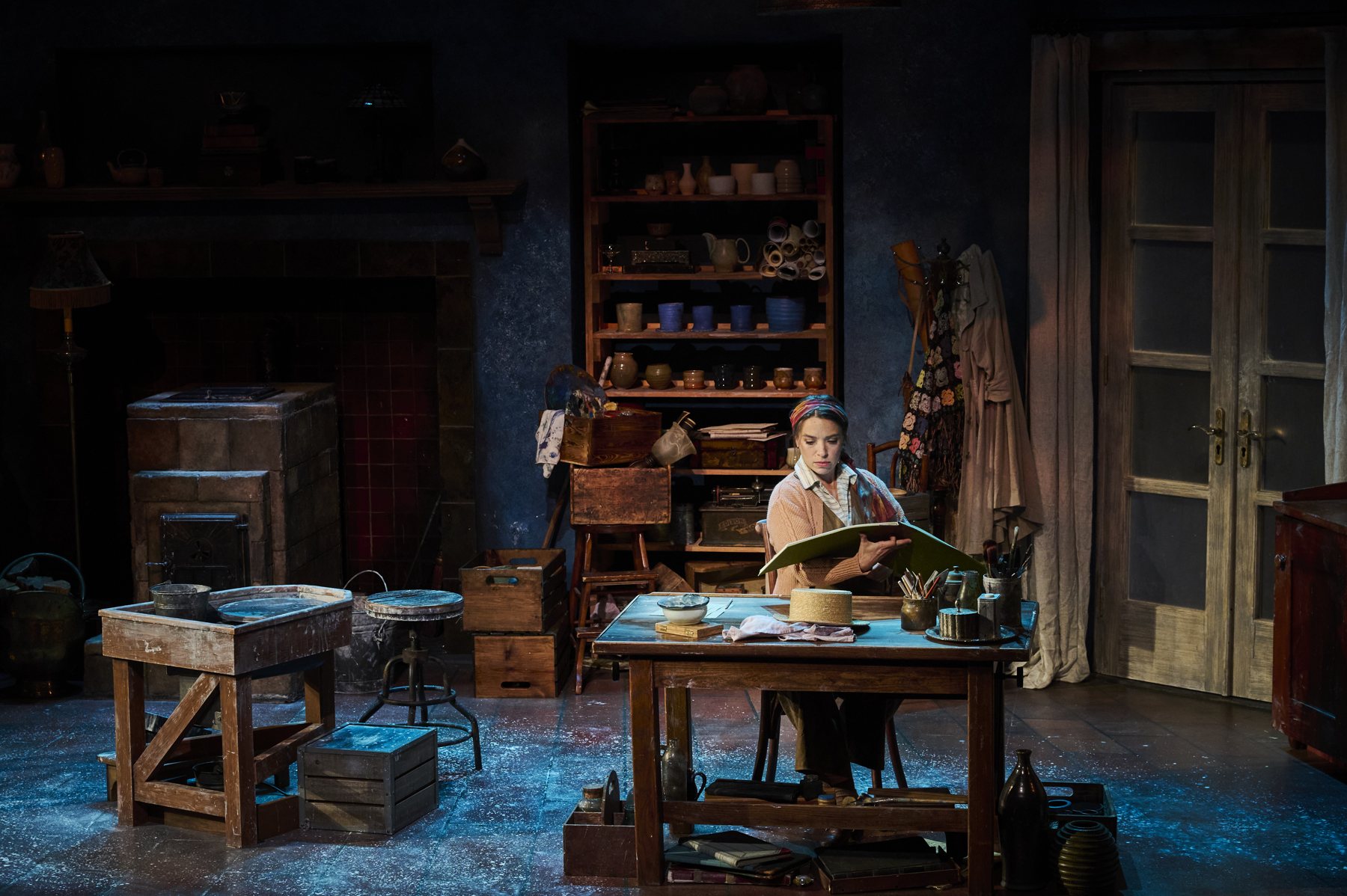 Marie-Berthe Cazin reading at her worktable in the pottery studio