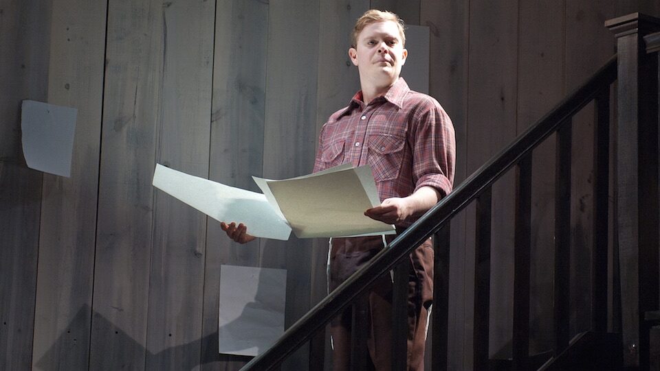 Asher on the staircase of the studio set, holding his drawings