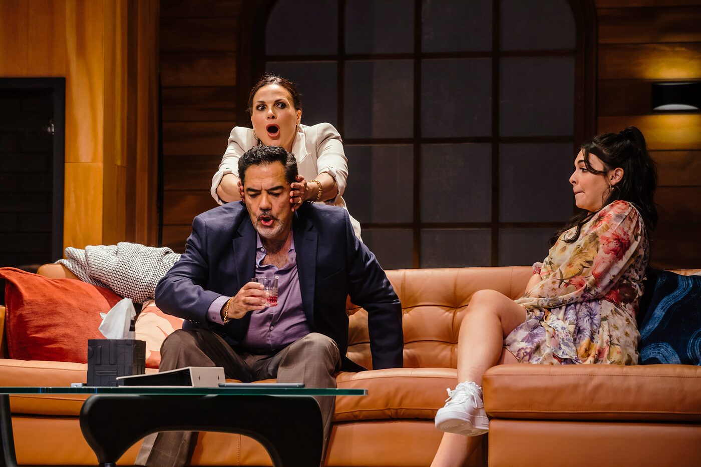 Characters gathered around the orange sofa in the living-room set of One of the Good Ones