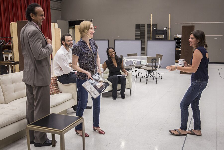 Kimberly Senior talking with the cast on the living-room set of Disgraced