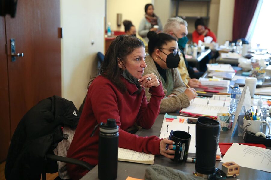Kimberly Senior at the rehearsal table for Our Daughters, Like Pillars, a masked colleague seated beside her