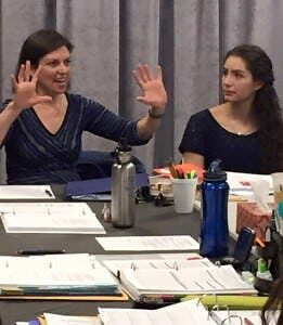 Kimberly Senior gesturing with both hands beside an actor at the table read for Sex With Strangers