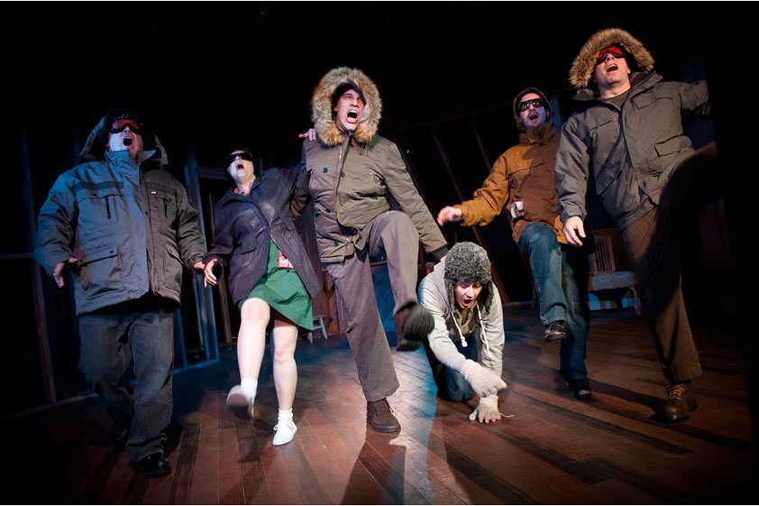 The full ensemble mid-stride in winter gear in The Conquest of the South Pole