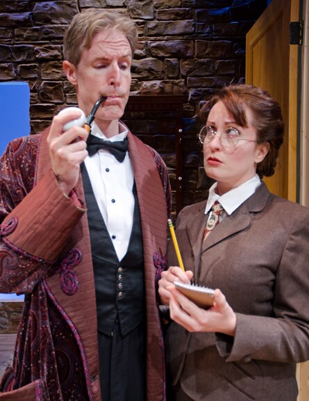 Two actors in period costume, one with a pipe and one in a plaid vest