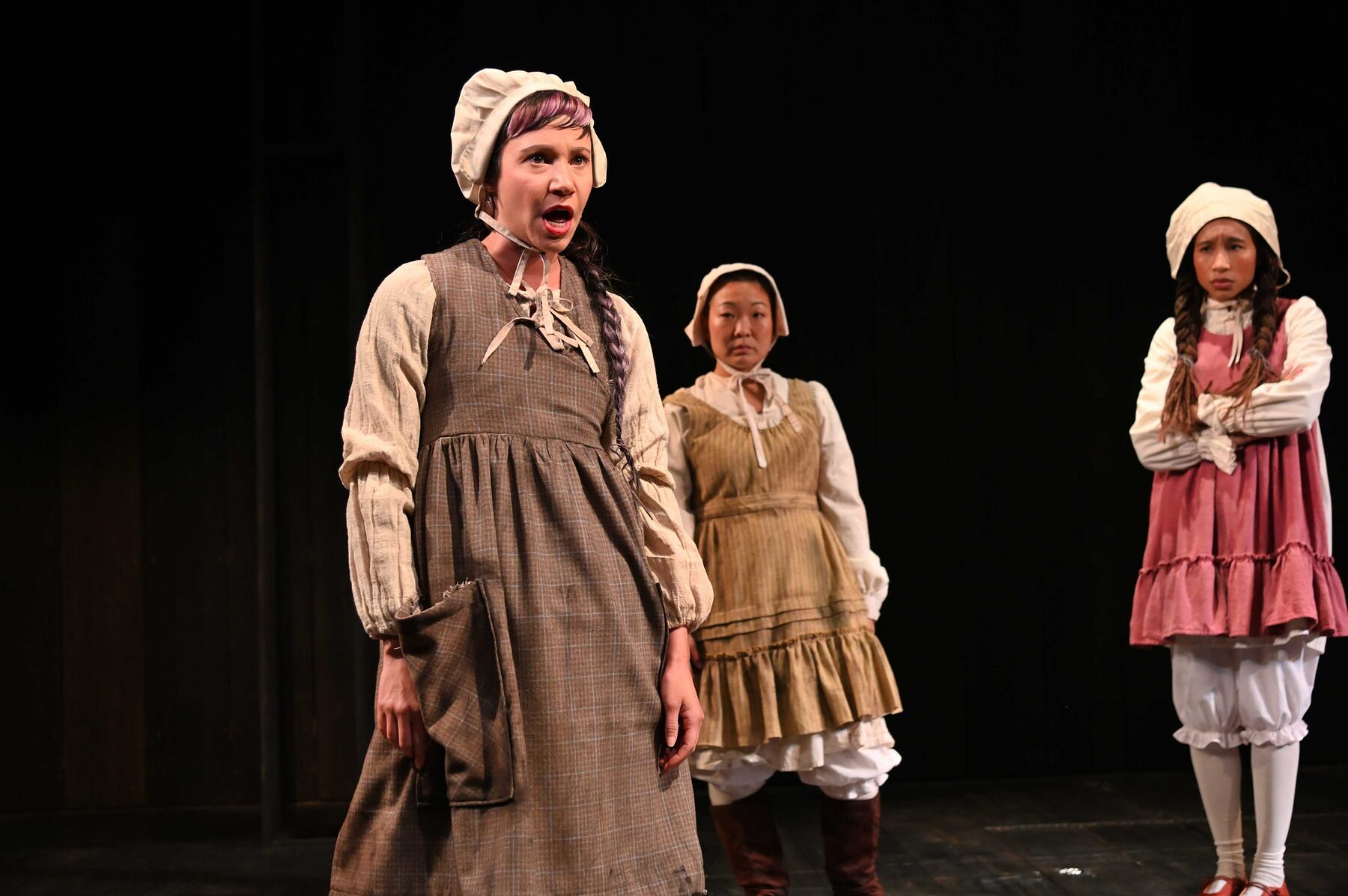 Three of the four young girls at the center of The Good John Proctor, in period costume on Trinity Rep's stage