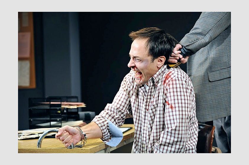 A handcuffed man shouting in pain as another grips his hair in The North Plan