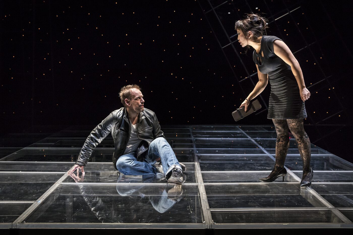 Mark L. Montgomery and Deanna Myers on a glass-floored stage under a field of stars in The Scene