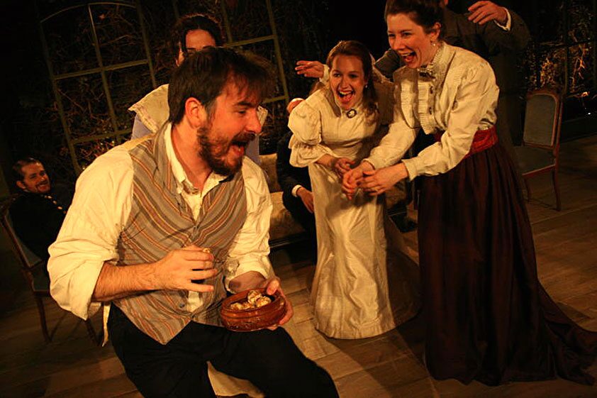 The cast of Three Sisters laughing together in a lively ensemble scene