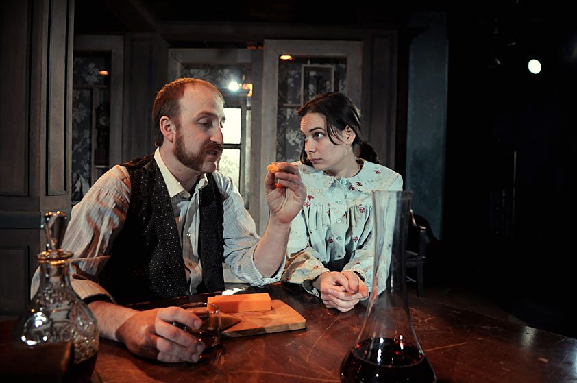 Two actors at a dinner table sharing cheese and wine in Uncle Vanya